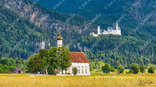 Neuschwanstein Castle, with its fairytale towers and majestic backdrop, stands proudly in the Bavarian Alps. In the foreground, a charming chapel adds a touch of history and serenity to the scene. Surrounded by lush forests and snow-capped mountains, the castle and chapel create a picturesque, romantic setting, making it one of the most iconic and photographed landmarks in Germany.