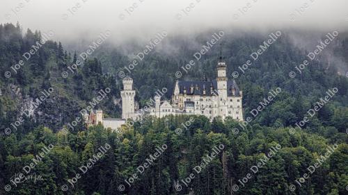 Mist gently envelops Neuschwanstein Castle, creating an ethereal atmosphere as the fog weaves through the towering turrets and surrounding forests. The iconic fairytale castle, perched on a mountain, is transformed into a mystical sight, offering a captivating and otherworldly view that enchants visitors year-round.